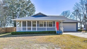 A single-story house with a covered porch, a garage, and a well-maintained lawn. - Updated Waterfront Escape w/ Dock & Fire Pit (Pensacola)