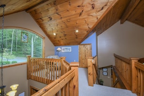 Step up to a balcony with forest views or relax in a cozy bedroom with a large window.