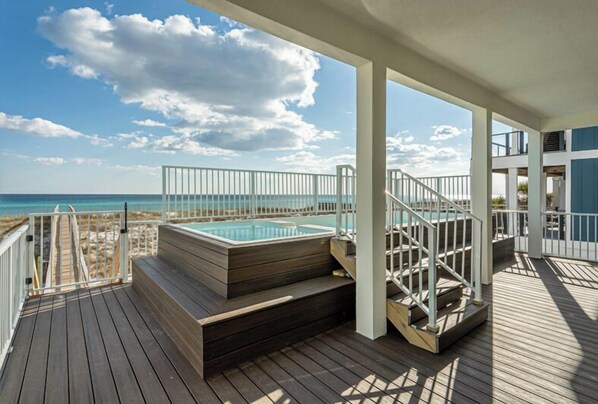 A wooden deck with a hot tub and stairs leading to a balcony overlooking the beach. - Sanctuary at Navarre Beach - 8 BR/8 BA Beach House w/pool. (Navarre Beach)