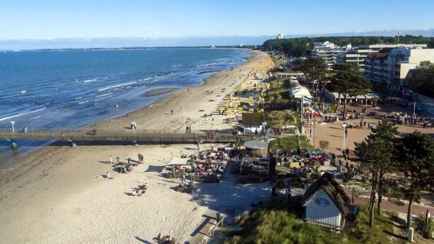 A coastal beach with a promenade, beach umbrellas, and a small hut. - Ter/215 - Terrassenhuegel - Seeblick (Scharbeutz)