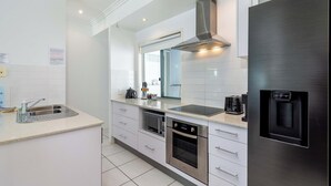 Een moderne keuken met witte kasten, roestvrijstalen apparatuur en een inbouwoven.