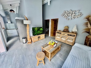 Un salon moderne doté d’un téléviseur à écran plat, de meubles en bois et d’un élément décoratif mural.