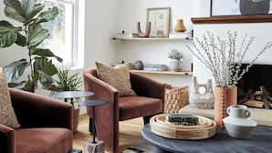 Una sala de estar moderna con un ventanal grande, una chimenea y un candelabro.