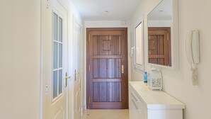 A hallway with a wooden door, a white counter with a phone, and a mirror. - VILLA RIVIERA - Luxury villa with private pool in a fabulous urbanization on the Costa del (Mijas)