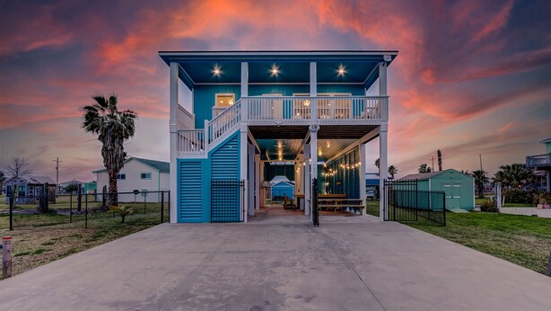 A two-story building with a balcony and a covered entrance. - Amazing Outdoor Space, Beautiful Interior with King Beds, Easy Walk to Beach! (Crystal Beach)