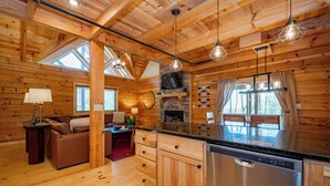 Ein Holzhaus-Interieur mit Küche, Essbereich und Wohnzimmer.