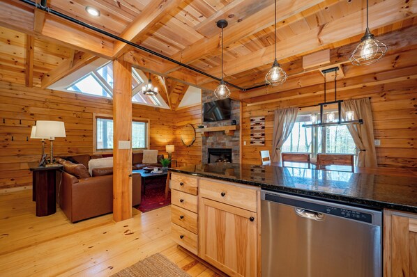 L’intérieur d’un chalet en bois comprend une cuisine, un coin repas et un salon.