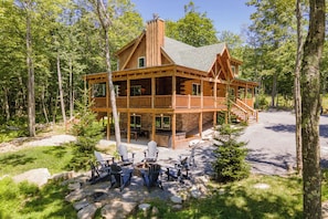 Eine Holzhütte mit einer Terrasse, umgeben von Bäumen.