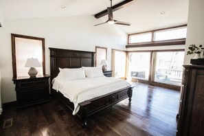 Un dormitorio espacioso con una cama grande, cabecera de madera y ventilador de techo.