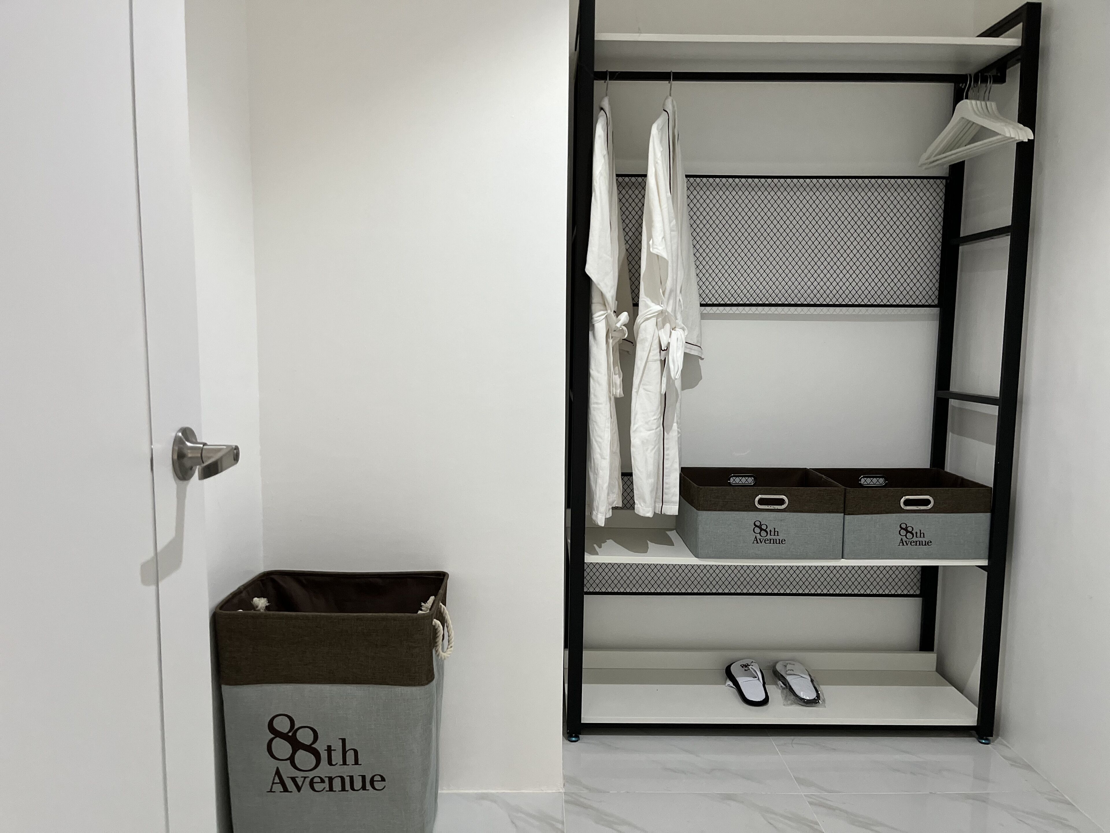 Un armario vestidor con batas colgadas, estantes y cajas de almacenamiento con la etiqueta "8th Avenue".