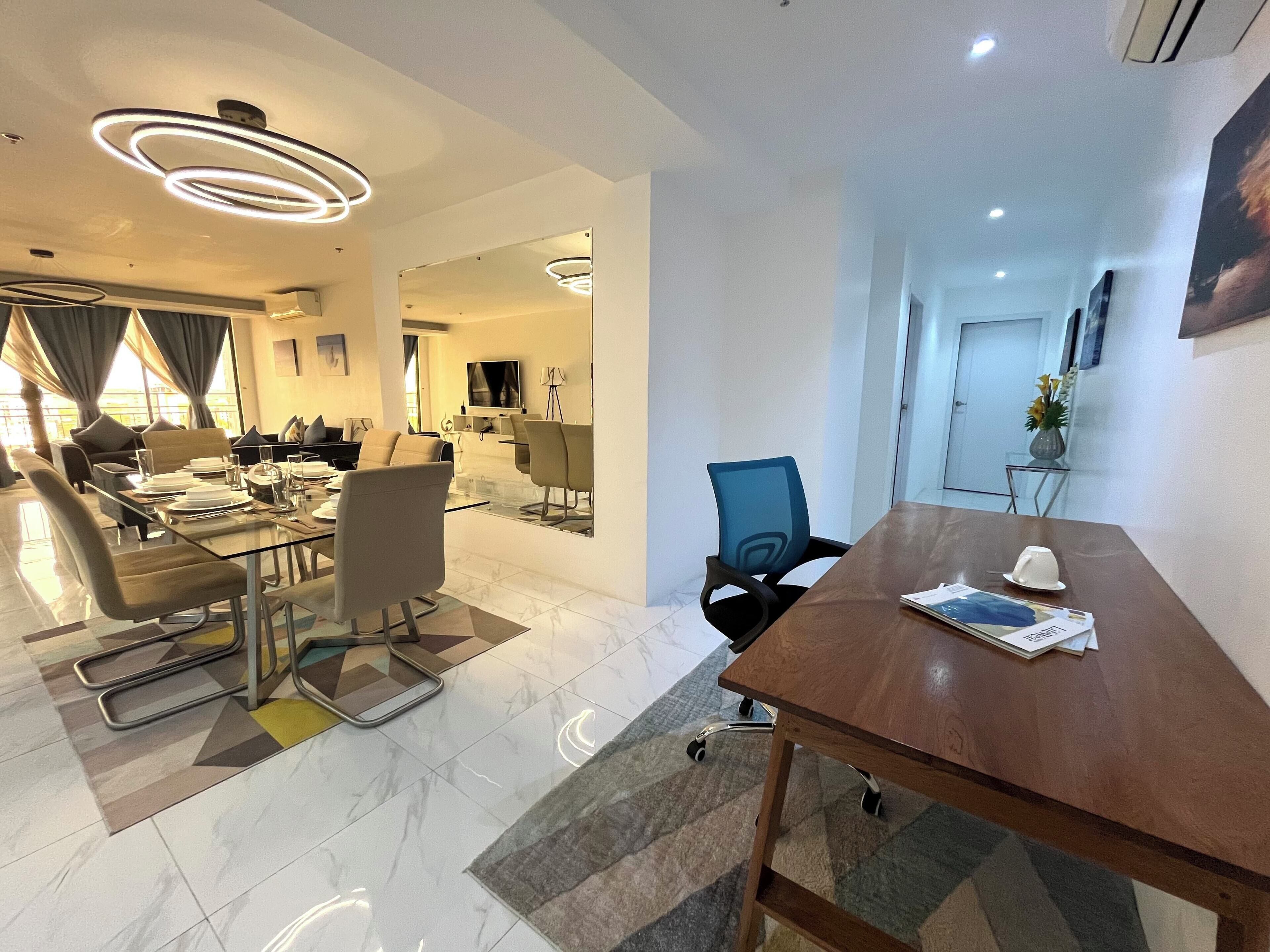 Uma sala de conferências moderna com mesa de vidro, cadeiras de couro e uma mesa de reuniões de madeira.