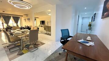 Uma sala de conferências moderna com mesa de vidro, cadeiras de couro e uma mesa de reuniões de madeira.