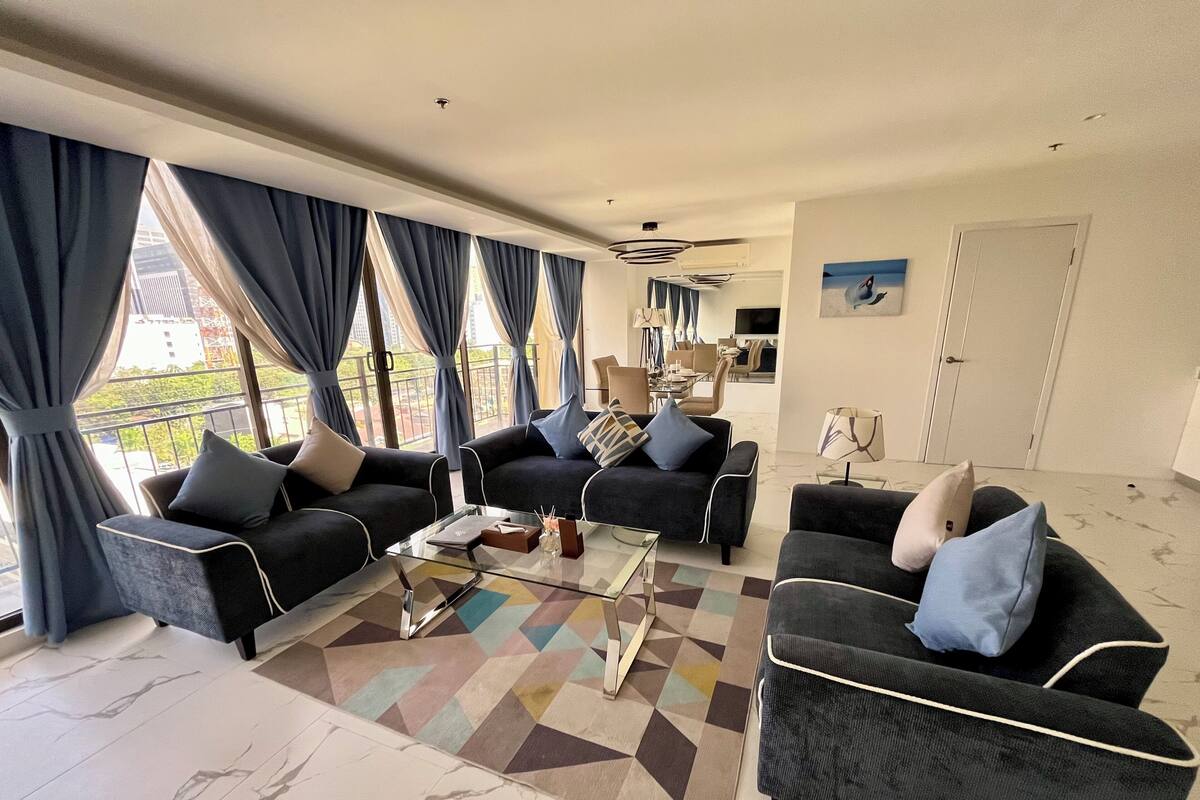 Een moderne woonkamer met twee banken, een bijzettafeltje en een kamerkleed met dessin.