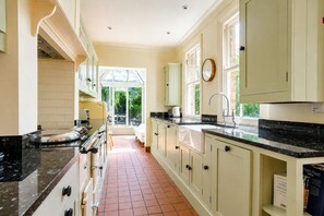 A kitchen with a large window, a sink, and a stove.