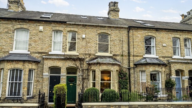 A row of terraced houses with a consistent architectural style, featuring multiple windows and doors, and a small front garden. - 7 St John's Crescent -  a family break that sleeps 6 guests  in 3 bedrooms (York)