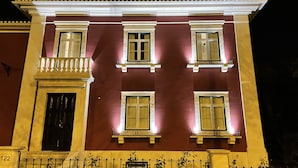 Un edificio de varios pisos con balcón, ventanas amplias y el número 122 en la fachada.