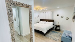A bedroom with a large ornate mirror, a bed with white linens, a nightstand, and a small table with a lamp. - 5 Min walking to the beach Luxury pool and Jacuzzi (Hollywood)