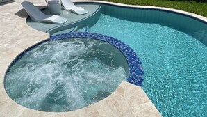 A swimming pool with a hot tub, lounge chairs, and a blue-striped umbrella. - 5 Min walking to the beach Luxury pool and Jacuzzi (Hollywood)