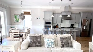 Una sala de estar moderna con un sofá de color claro, cojines estampados y una mesa de centro con objetos decorativos.