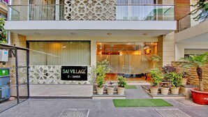 A modern building with a sign reading "SAI VILLAGE C-2602A". - Treebo Sai Village Gold Souk - Sec 43 (Gurugram)