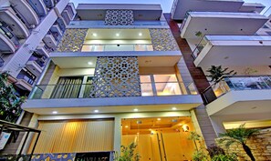 A multi-story residential building with balconies, a patterned facade, and a gated entrance. - Treebo Sai Village Gold Souk - Sec 43 (Gurugram)