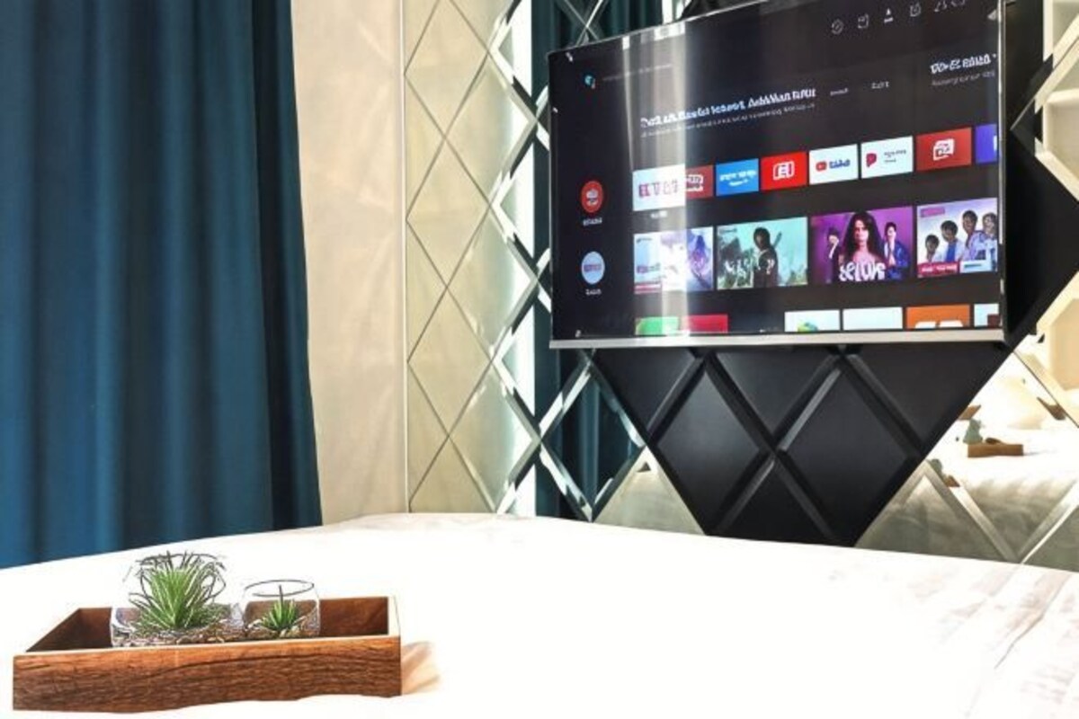 A flat-screen TV mounted on a wall, displaying a streaming service interface with various content options.