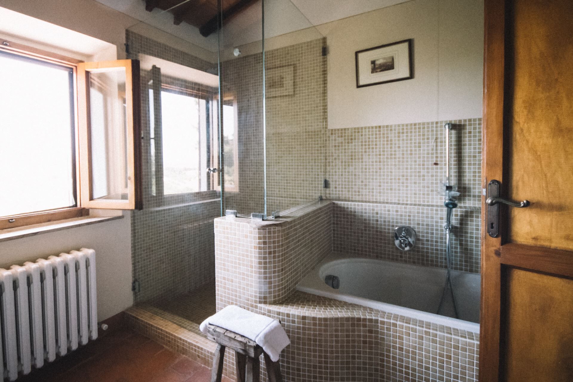 A bathroom with a bathtub, a shower, and a window.