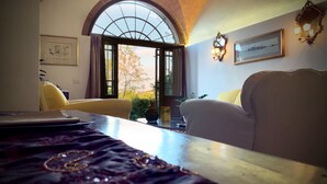 Une pièce dotée d’une grande fenêtre, d’un canapé, d’une table et d’un miroir décoratif.