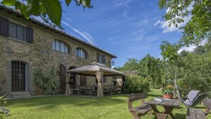 A stone building with a covered patio area, outdoor seating, and a lawn. - Beautiful villa in the heart of Mugello. Pool, jacuzzi, sauna. (Borgo San Lorenzo)