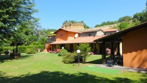 A traditional villa with a spacious patio, a covered outdoor seating area, and a lush garden. - Villa composed of 3 apartaments. Private pool (Castelfranco Piandisco)