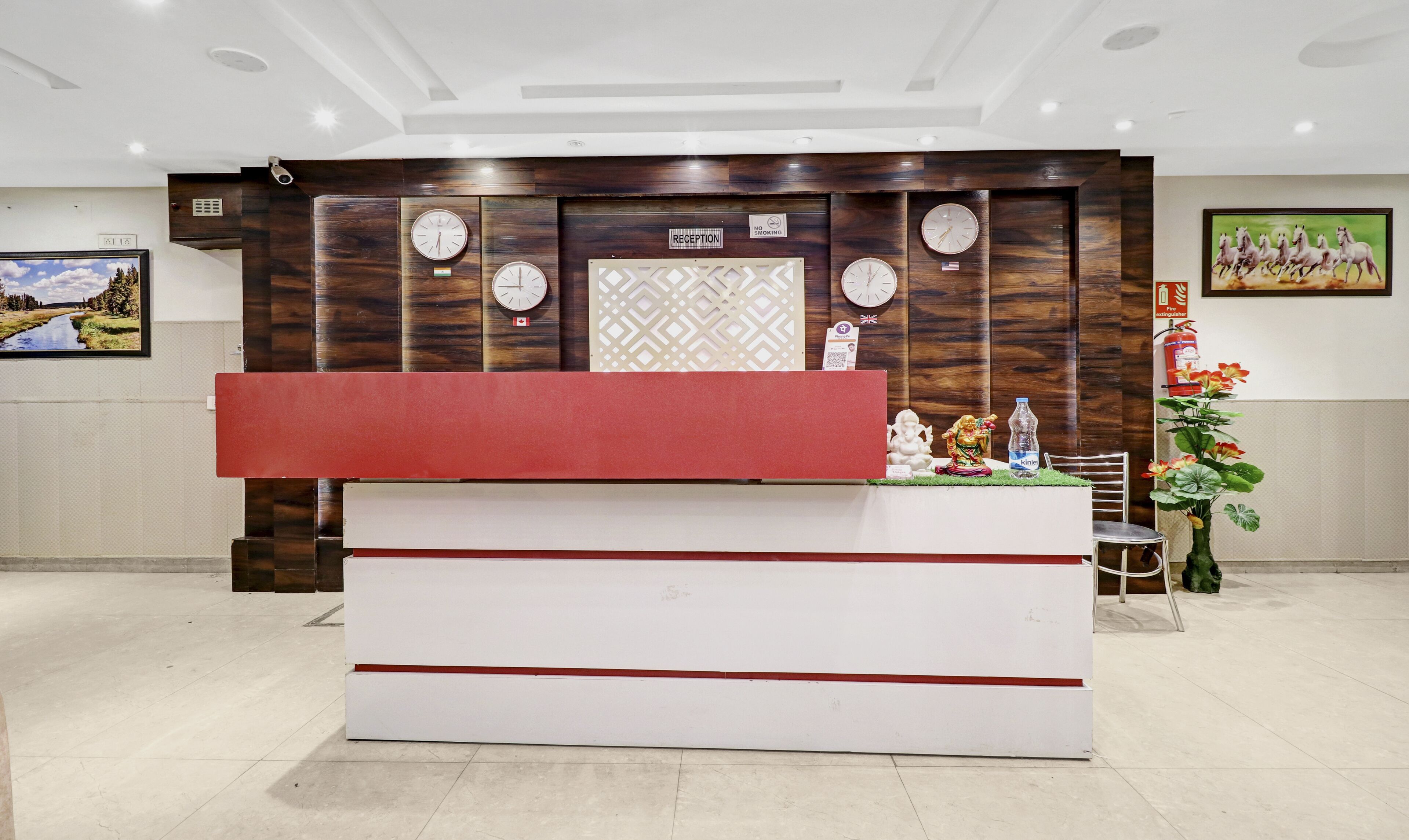 A reception desk with clocks, a reception sign, and a no-smoking sign.