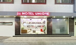 A hotel entrance with a prominent sign reading "HOTEL UNIQUE". - Itsy Hotels Unique (Amritsar)