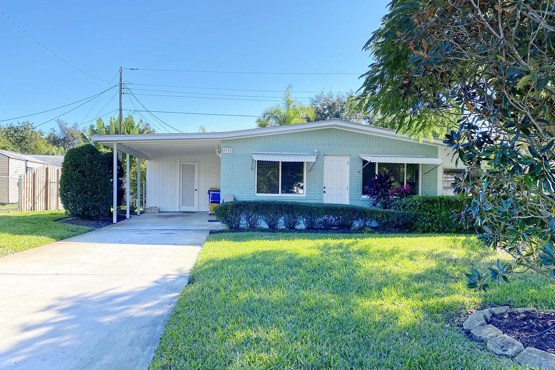 A single-story house with a front porch, a covered driveway, and a well-maintained lawn.
