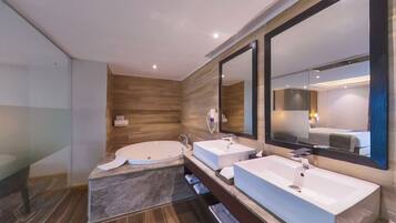 Un baño moderno con dos lavamanos, una bañera grande y un espejo.