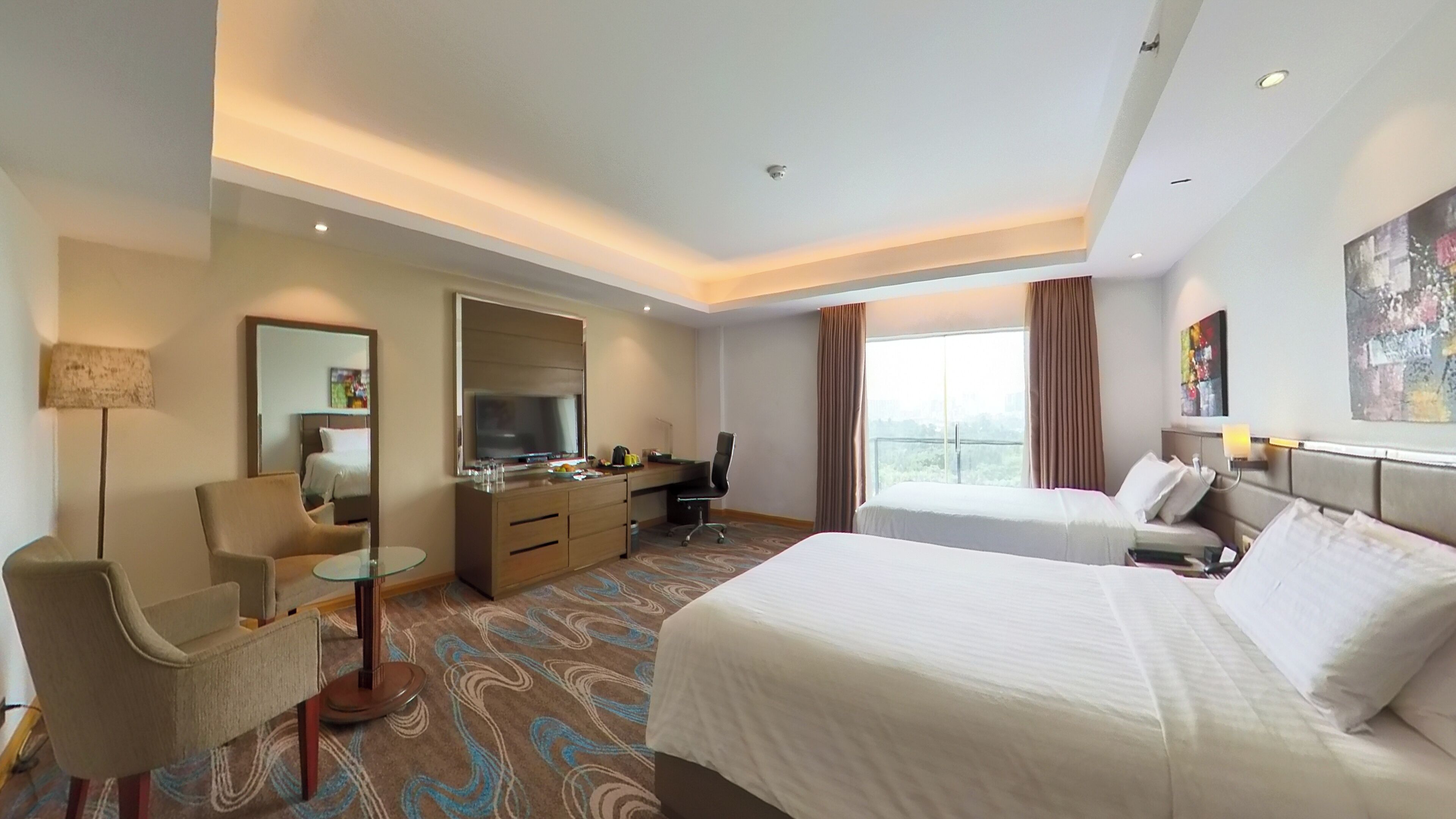 Una habitación de hotel con una cama, un escritorio con una silla, un televisor y un ventanal grande.
