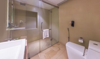 A modern bathroom with a glass-enclosed shower, a white toilet, and a sink.