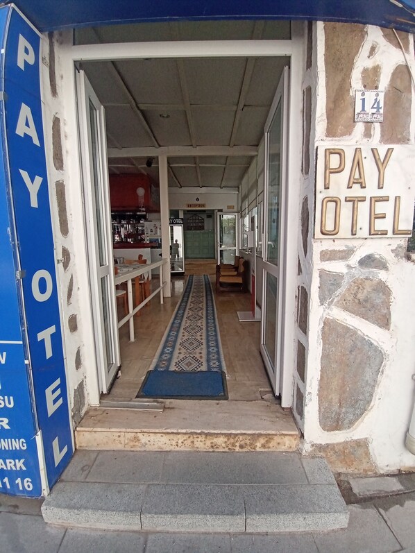 L’entrée d’un hôtel, avec un comptoir d’accueil, un téléphone à pièces et un espace d’attente.