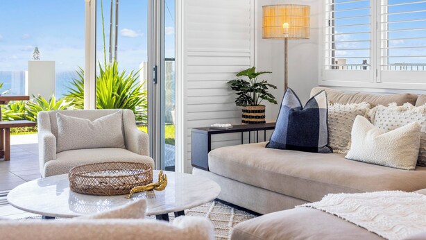 Una sala de estar moderna con un sofá, un sillón y una mesa de centro.