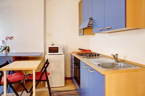 A compact kitchen with a microwave, stove, sink, and a small refrigerator. - Holiday Apartment 'Foresteria al Cantun' with Wi-Fi (Sondrio)