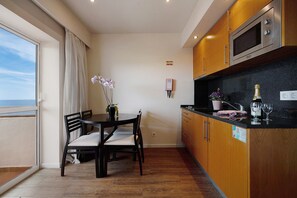 Une cuisine avec des meubles en bois, un four à micro-ondes et un coin repas comprenant une table et des chaises.
