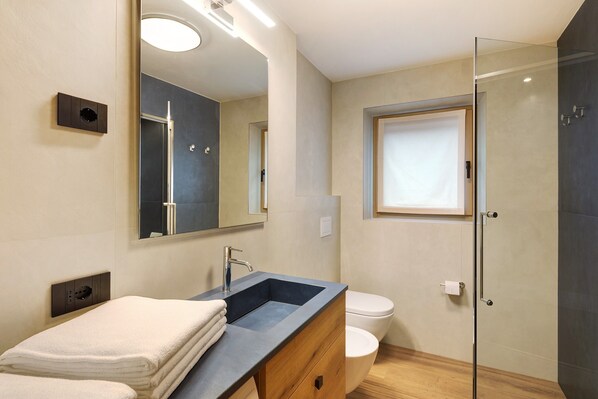 Une salle de bain moderne avec un lavabo, un miroir et des toilettes.