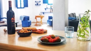 Un'area pranzo con un tavolo apparecchiato con cibo, una bottiglia e un bicchiere d'acqua.