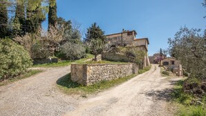 A rural road leading to a stone-walled house with a stone staircase, surrounded by trees and shrubs. - Holiday Apartment "Arianna" with Terrace & Wi-Fi (Montegabbro)