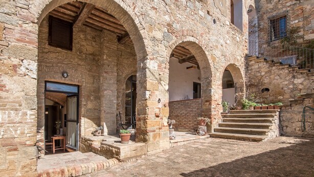 An arched stone building with a door, steps, and potted plants. - Holiday Apartment "Arianna" with Terrace & Wi-Fi (Montegabbro)