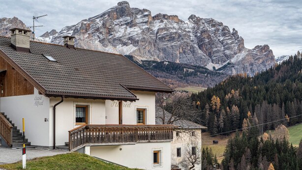 A two-story house with a balcony, a staircase, and a view of snow-capped mountains. - Holiday Apartment 'Ciasa Alfred' with Mountain View, Wi-Fi & Balcony (La Villa)