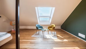 A room with a sloped ceiling, a skylight, wooden flooring, and two chairs. - Holiday Apartment 'Meine Bleibe - Olive' with Mountain View, Garden & Wi-Fi (Eppan an der Weinstraße)