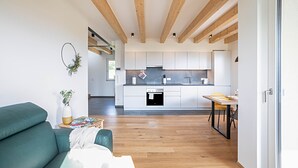 A modern interior with a living area, kitchen, and dining space. - Holiday Apartment 'Meine Bleibe - Olive' with Mountain View, Garden & Wi-Fi (Eppan an der Weinstraße)