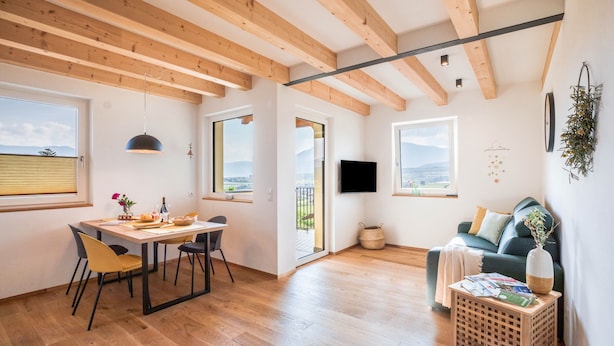 A modern interior with wooden beams, a dining area, a sofa, and a TV. - Holiday Apartment 'Meine Bleibe - Olive' with Mountain View, Garden & Wi-Fi (Eppan an der Weinstraße)