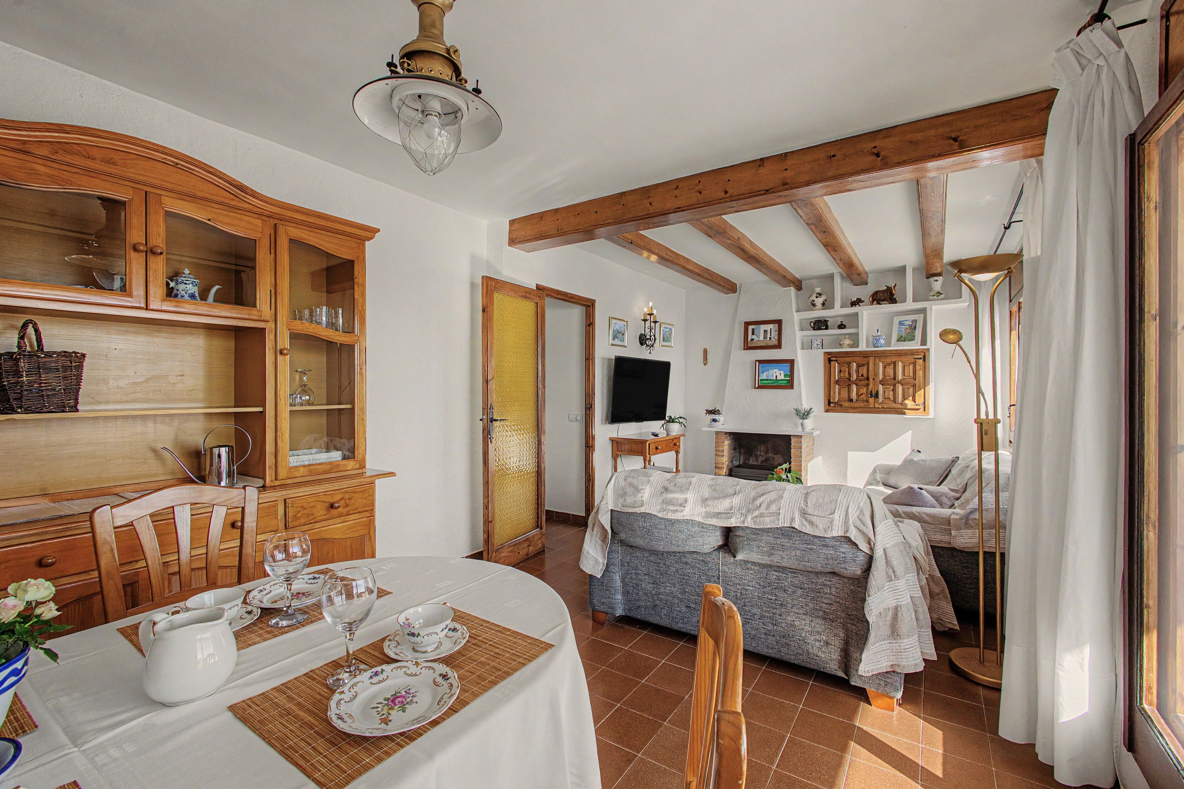 A traditional room with a dining area, a sofa, and a fireplace.