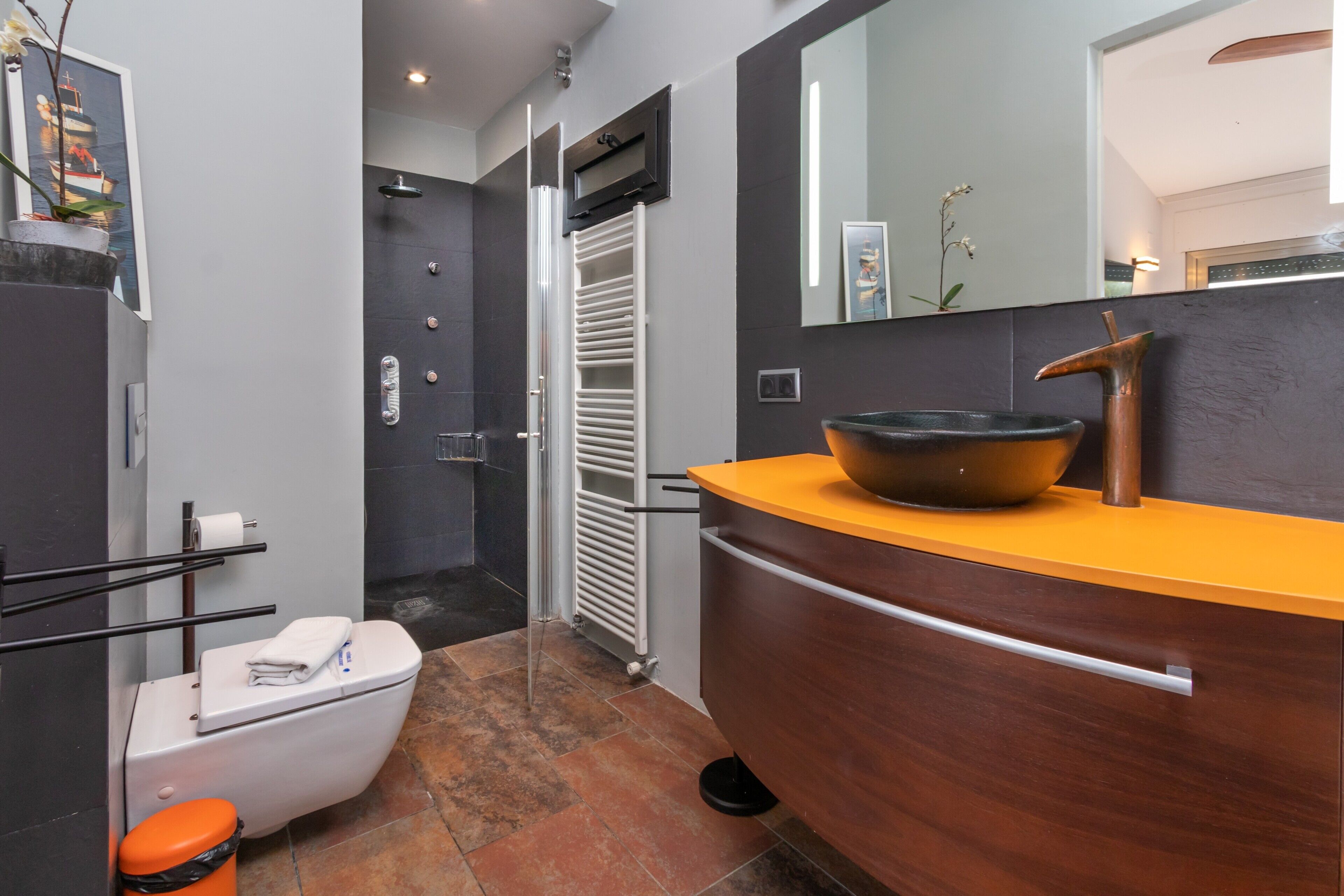 Een moderne badkamer met toilet, wastafel en douche.